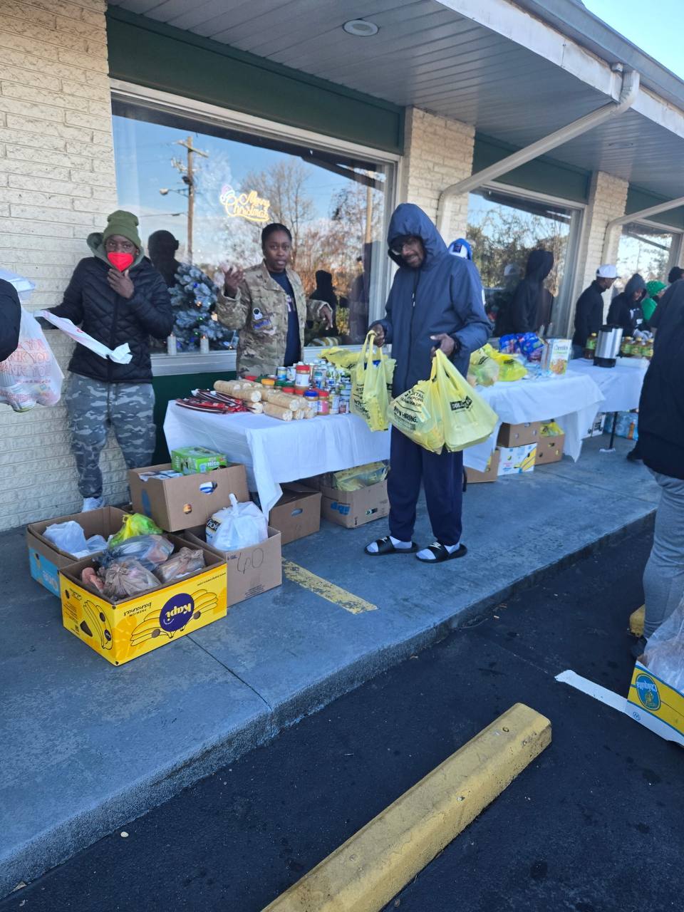 Community members picking up bags of groceries at a winter distribution event
