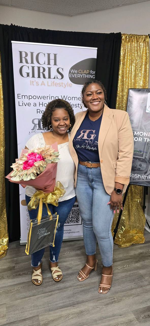 A Rich Girls Foundation attendee receiving a gift bag and bouquet at an event